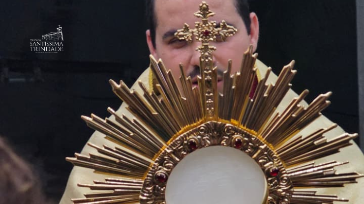 Foto com padre Adriano segurando o hostensório com Jesus em adoração